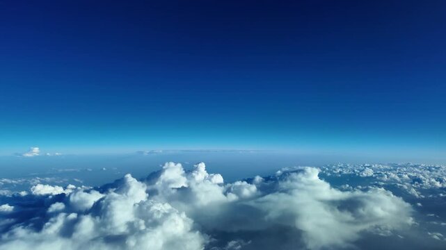 An immersive cockpit POV video take from a jet cockpit flying at supersonic speed over broken storm clouds, under. a deep blue sky, with visible earth curvature. 15000 m high.