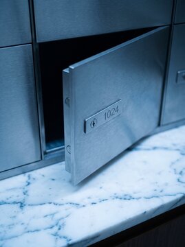 Modern Brushed Metal Mailbox with Open Door Number 1024 on Marble Countertop, Secure Private Post Office Box for Apartment Building Lobby, Industrial Interior Design Concept, High Quality Detail Shot