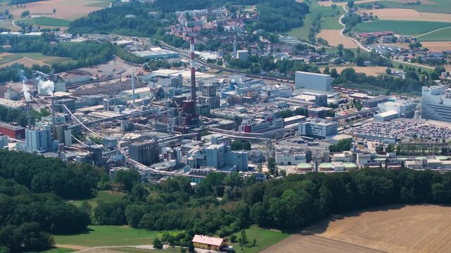 Expansive aerial perspective of the Lenzing Plastics industrial complex, showing the large manufacturing facility surrounded by green forests