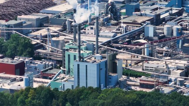 Aerial view of the Lenzing industrial complex, a major producer of thermoplastic and polymers. Smokestacks emitting smoke over the facility