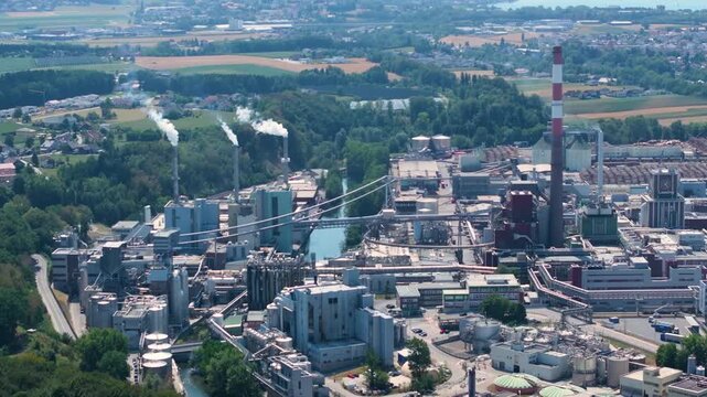 Extensive industrial complex of Lenzing Plastics in Austria, showing buildings, smokestacks, and surrounding green landscape from an aerial perspective