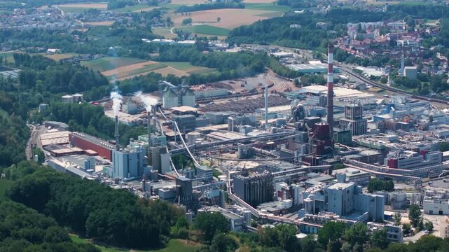Vast industrial complex of Lenzing Plastics, a large polymer and thermoplastic production factory, viewed from above, with smoke from chimneys