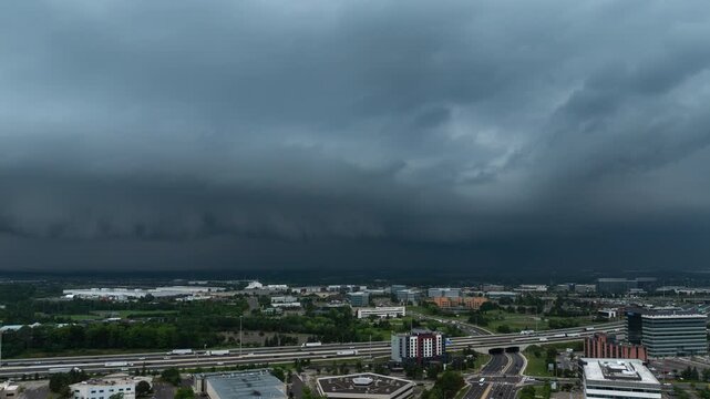 An ominous shelf cloud moves in, turning the sky dark over Mississauga office parks and highways. The rapid transition captures the intensity of an approaching summer storm.