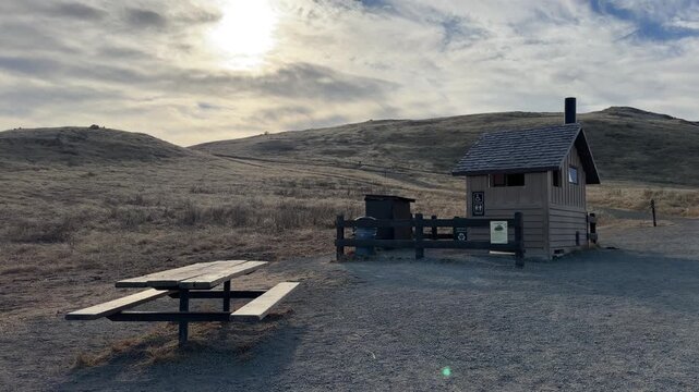 A hiker pauses near a scenic overlook along the Mission Peak trail with expansive dry hills and blue sky in the distance