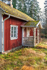 Wooden red idyllic cottage with a veranda in a forest at autumn © Lars Johansson