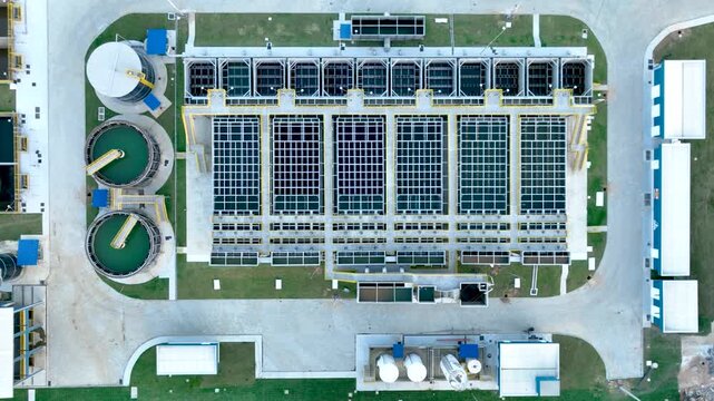 Wastewater treatment plant with circular clarifier tanks processing sewage. Environmental sanitation infrastructure. Aerial view.