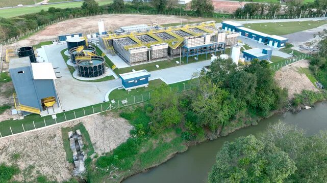 Wastewater treatment plant with circular clarifier tanks processing sewage. Environmental sanitation infrastructure. Aerial view.