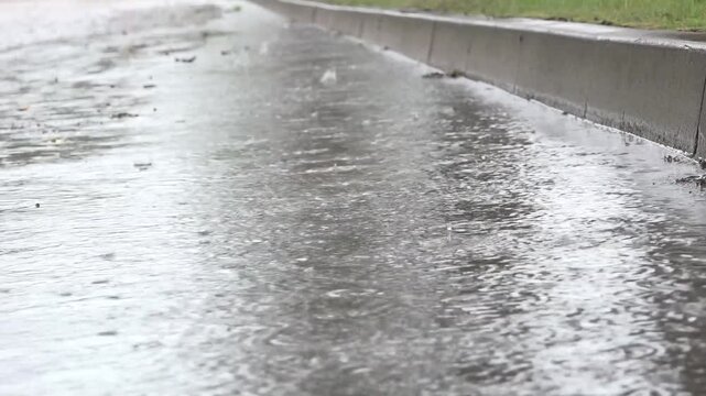 Wet Sidewalk Puddles Reflecting Rain On Urban Curb During Overcast Spring Shower