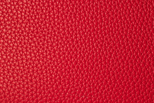 Macro background texture of bright red pebbled genuine leather material