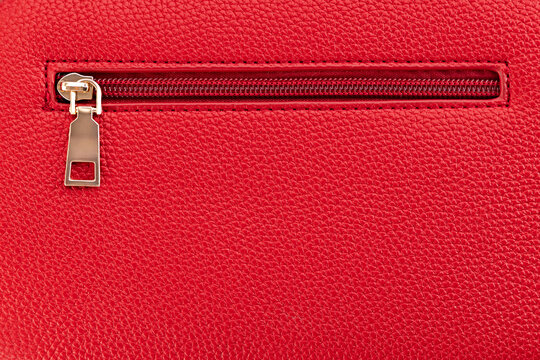 Macro close up of golden zipper on red leather texture background