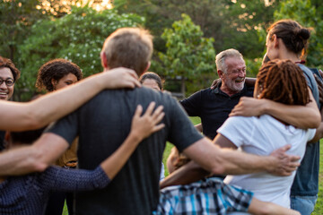 Fototapeta premium Diverse group embracing outdoors joyfully