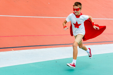 Child in superhero costume running on a colorful track. © Rawpixel.com
