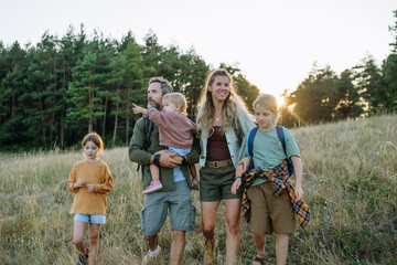 Naklejka premium Family hiking together through countryside during summer camping trip.