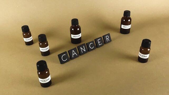 Conceptual video illustrating the ongoing medical research and development for a cancer vaccine, with small amber vials surrounding the word cancer symbolizing the potential for a breakthrough