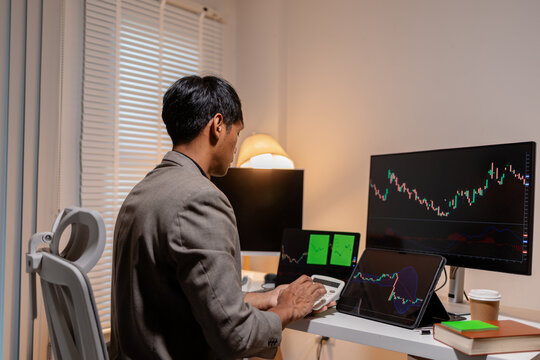 Professional stock trader reviewing market charts with sticky notes across multiple monitors, laptop, and tablet to analyze price trends, plan trading strategies, and manage investment decisions.