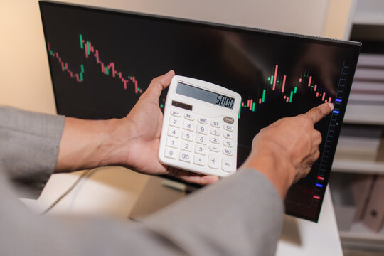 Professional financial analyst reviewing stock market charts across multiple screens using a tablet, laptop and calculator to evaluate price movements, technical indicators, and investment strategies.