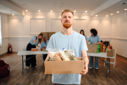 Volunteer man holding donation box with food
