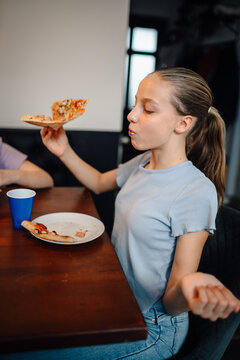 Young girl enjoying pizza slice during meal