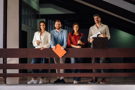 Business professionals standing together in office hallway