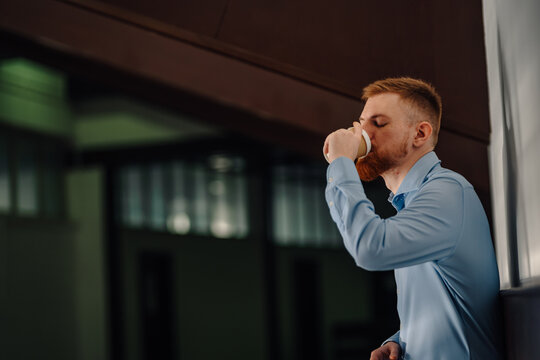 Man drinking coffee from paper cup indoors