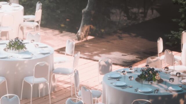 White tables are arranged in a garden setting with floral centerpieces. The scene shows a calm afternoon atmosphere with greenery surrounding the area.