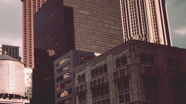 Buildings stand tall against the afternoon sky. A mix of modern glass and old stone highlights the citys architecture. People walk below unaware of the scenes detail.
