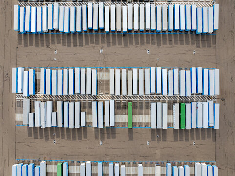 Top-down perspective of organized storage containers in an open, arid area