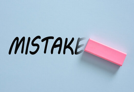 Eraser removing mistake word on a pale blue background