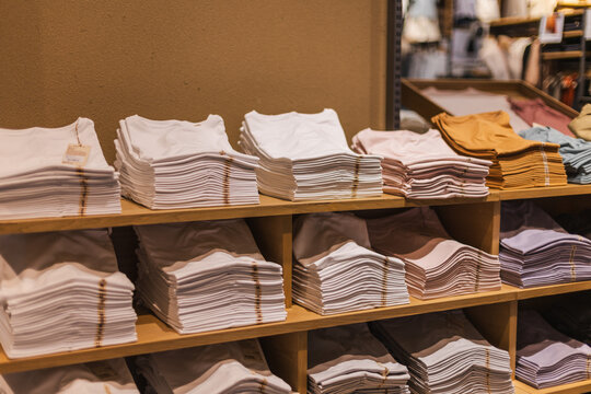 Neatly Folded T-Shirts on Wooden Store Shelves