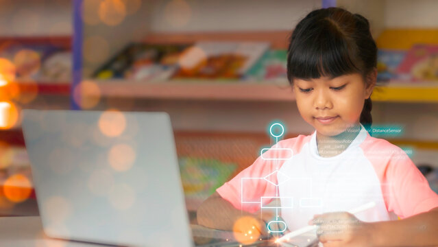 Cute Asian girl learning computer programming and robotics coding with futuristic digital flowchart overlay on laptop screen in classroom.