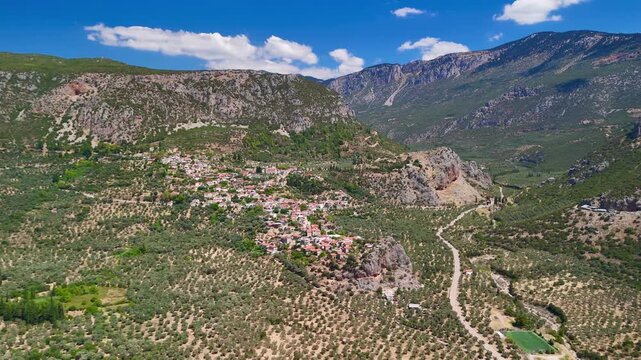 Scenic aerial footage of a traditional village nestled in a lush valley surrounded by mountains