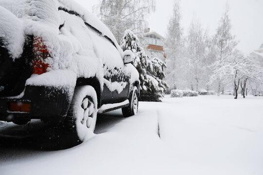 Snow-Covered SUV Parked in Winter Landscape Near Snow-Laden Trees