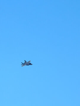 Modern Military Stealth Fighter Jet Flying in Clear Blue Sky