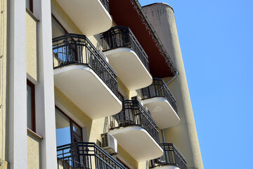 Modern apartment building facade with balconies against blue sky