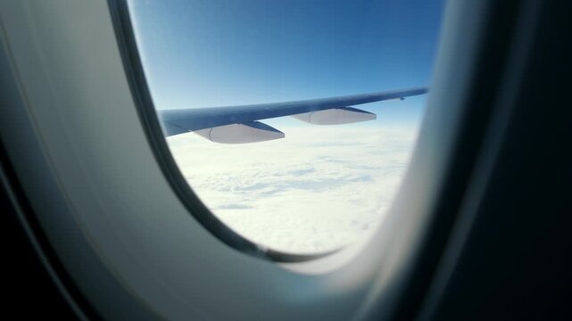 Fear of flying and travel by plane, view on aircraft wing in sky through window. Flying anxiety, flying phobia, flight phobia, aviophobia, aerophobia, pteromechanophobia, or pteromerhanophobia