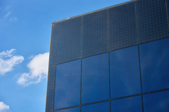 Solar panels on modern building facade under blue sky