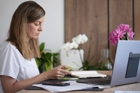 Woman counting euros while managing household bills at home