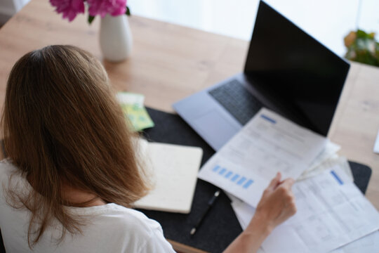 Woman reviewing bills and financial documents at home