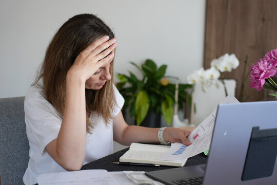 Worried woman checking household bills and expenses at home