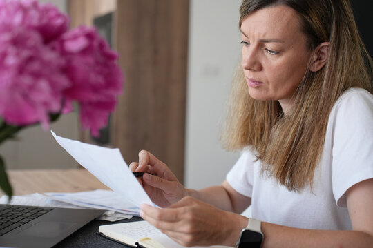 Worried woman checking household bill and expenses at home