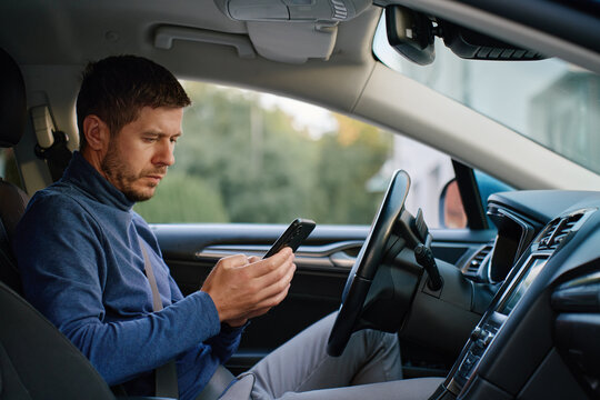 Man using smartphone while driving car
