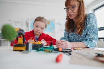 Naklejka premium Girl with down syndrome learning science and technology, robotics activity.