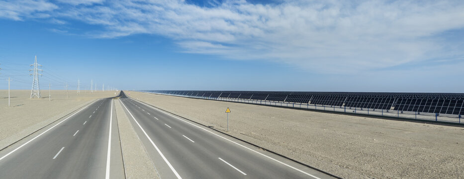 Straight Desert Highway Beside Endless Solar Panel Farm