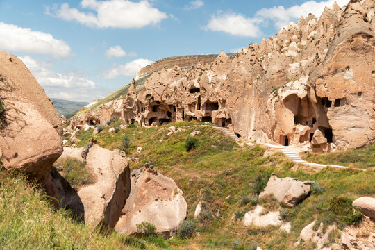 Ancient cave dwellings carved into volcanic rock formations in C