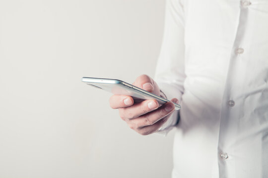 Close up of a man using mobile smart phone with blank screen.