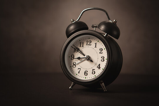 Retro alarm clock on dark background.