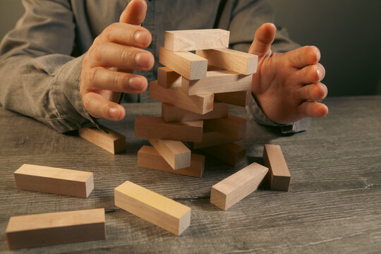 Businessman building a tower of wooden blocks. Concept of risk, management and development.