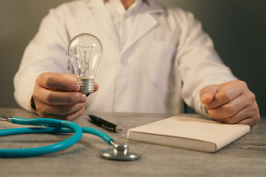 Close-up of a doctor's hands with a stethoscope and a light bulb