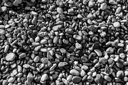 Black and white detailed close up of rounded shingle stones on the shore at Penmon Point