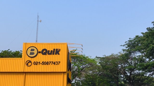 Jakarta, Indonesia - September 15, 2026: B-Quik Building at Jakarta Garden City with Yellow commercial building facade with signage against a clear blue sky.